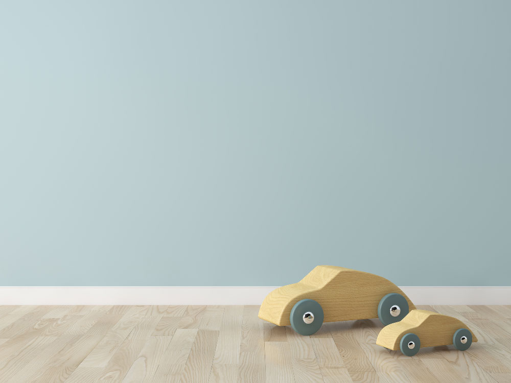 Two wooden car toys on the floor.